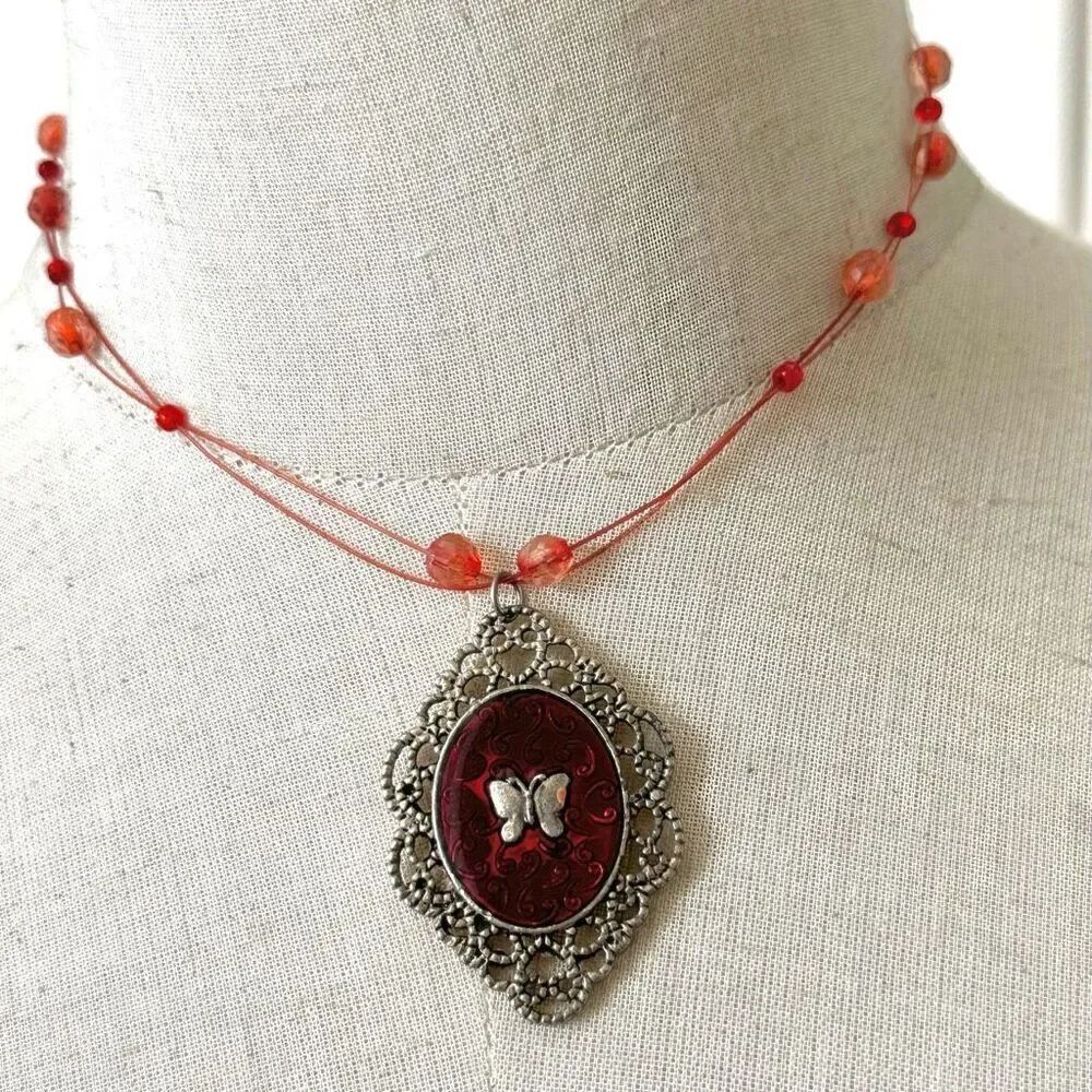 Red butterfly pendant necklace on pink cord